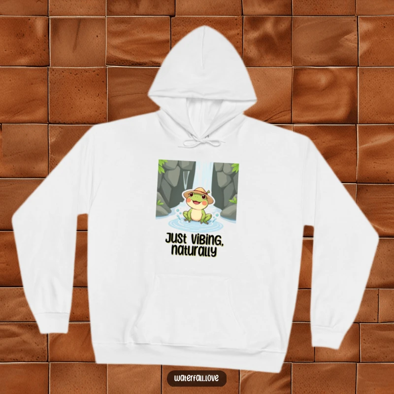 Funny frog wearing a straw hat, splashing happily in a puddle by a waterfall, featured on a cozy hoodie.