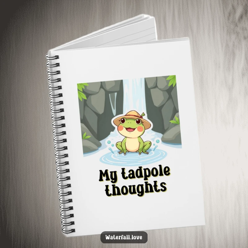 Funny frog wearing a straw hat splashing in a puddle by a waterfall, featured on the cover of a funny notebook.